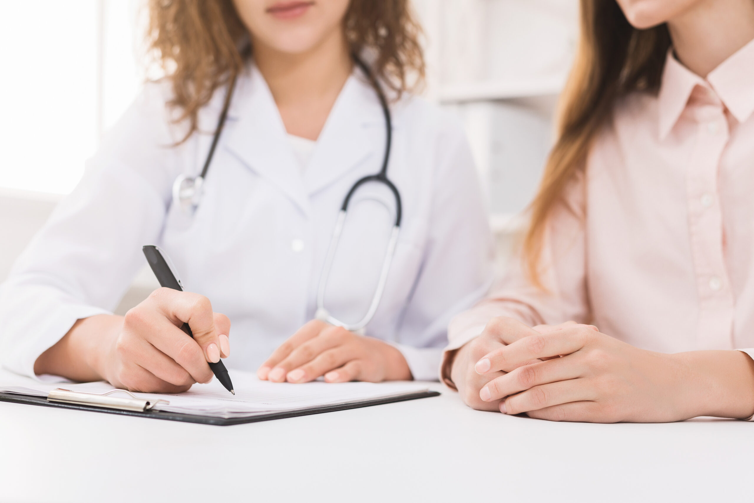 Physician taking notes during a primary care visit